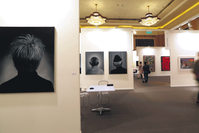 Visitors pass by art works titled ,Portraits, by Pakistani artist Ayaz Johio displayed at Art Dubai.