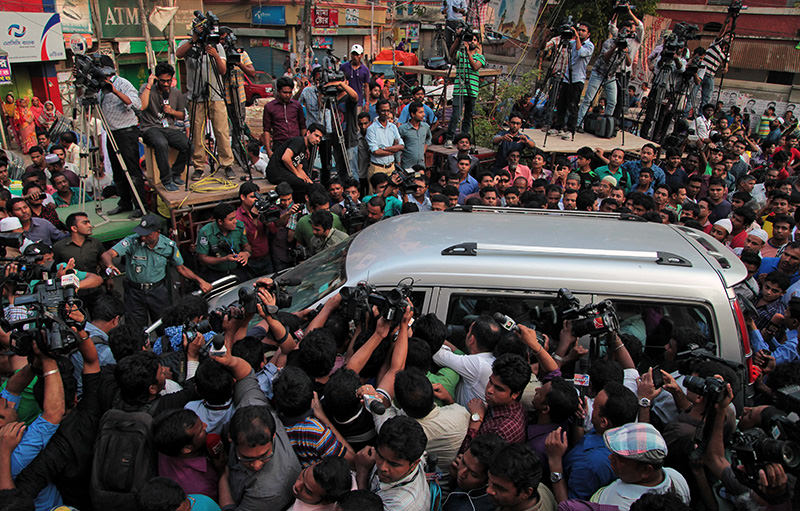 Journalists surround the car carrying family members of Mohammad Qamaruzzaman, as they leave the Central Jail after meeting Qamaruzzaman in Dhaka, Bangladesh AP Photo