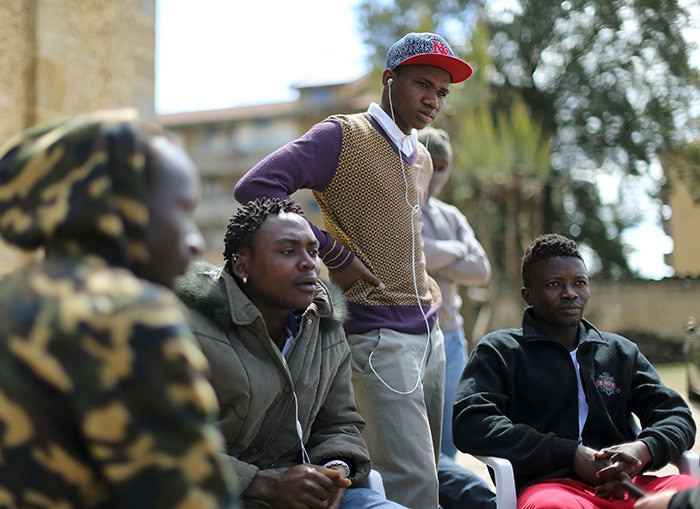 Adolescent migrants Mustafa (2nd R) from Gambia and Ishmael (R) from Sierra Leone stand in a courtyard at an immigration centre in Caltagirone, Sicily March 18, 2015 (Reuters Photo)