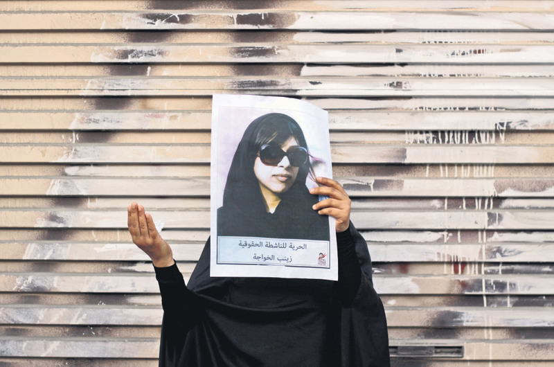 In this file photo, a Bahraini anti-government protester holds up a picture of jailed opposition human rights activist Zainab al-Khawaja.