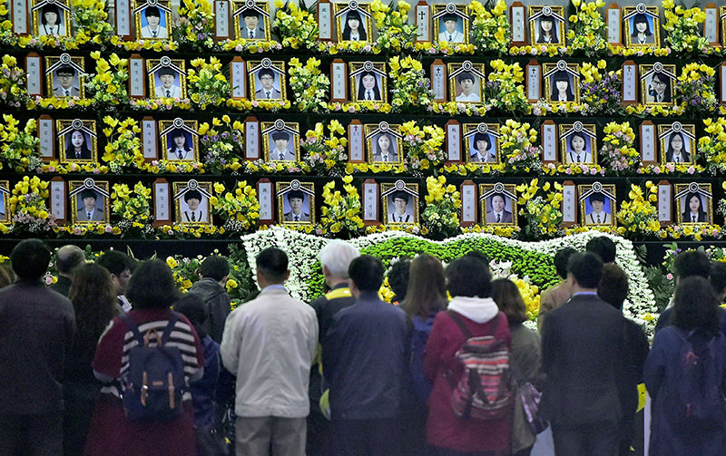 People pay a tribute at a group memorial altar for the victims of the sunken South Korean ferry Sewol at a remembrance hall in Ansan on April 16, 2015 (AFP Photo)