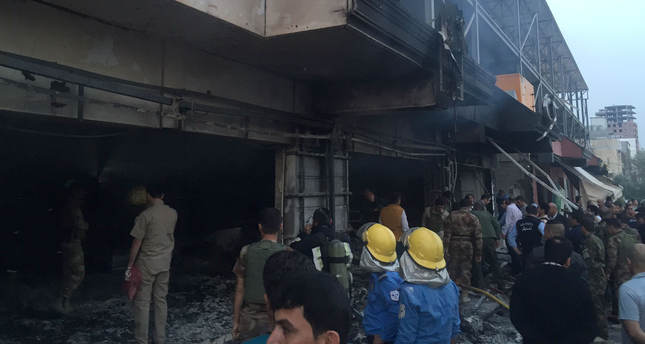 Emergency workers gather at the scene of a car bomb in northern city of Irbil, Iraq, Friday, April 17, 2015