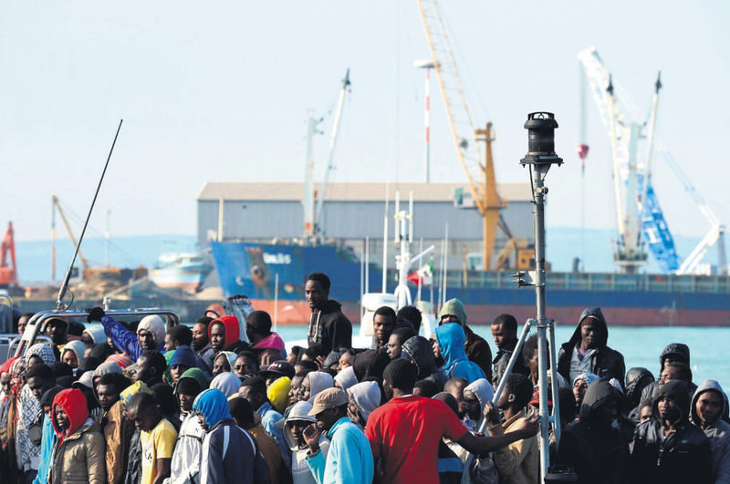 Rescued migrants stand as they disembark from the Italian vessel Guardia di Finanza Denaro at the Sicilian harbor of Catania on April 23.