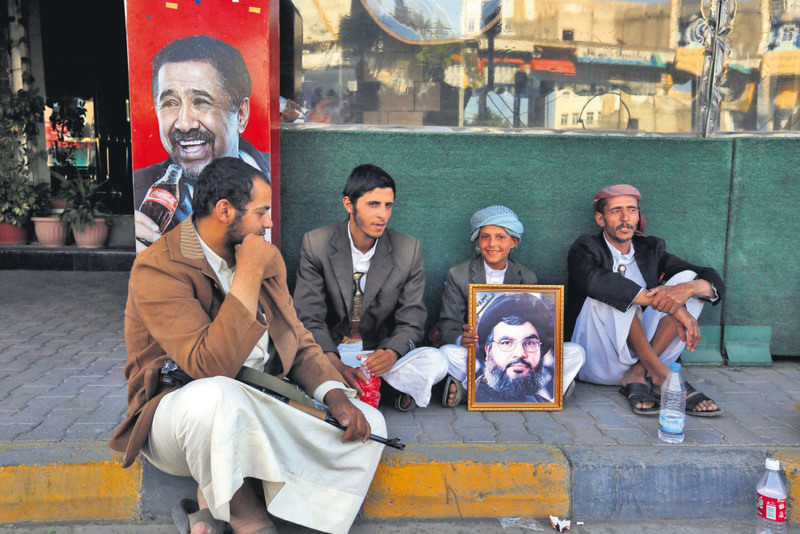 A young Yemeni holds a picture of Hezbollah leader, Hassan Nasrallah, while waiting to participate in a rally demanding an end to Saudi-led military operations on Houthis and their allies, in Sana'a, Yemen.