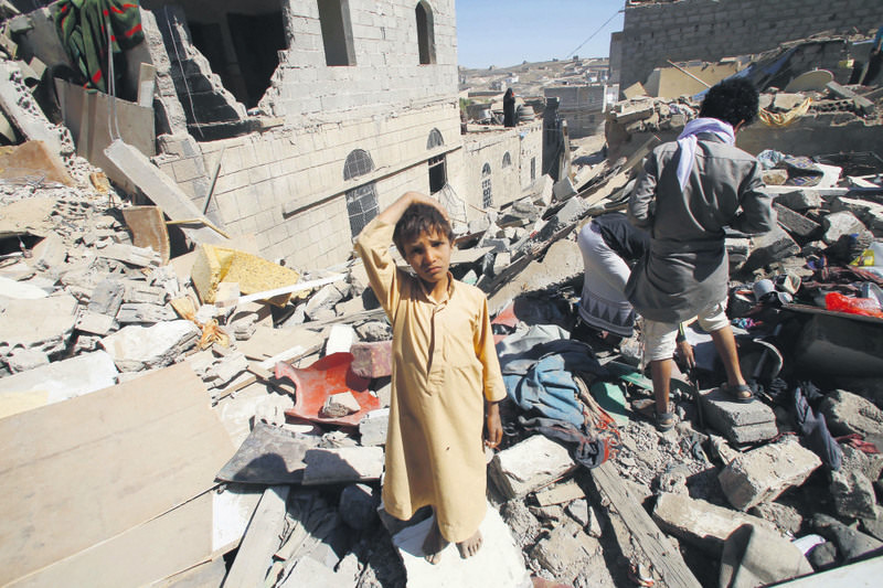A boy stands in a rubble of houses destroyed by the Saudi-led airstrikes in Sanaa, Yemen, on Friday, May 1, 2015.