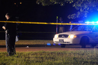 A Hattiesburg, Miss., lawman investigates the scene where two Hattiesburg police officers were shot to death, Saturday night, May 9, 2015 (AP Photo)