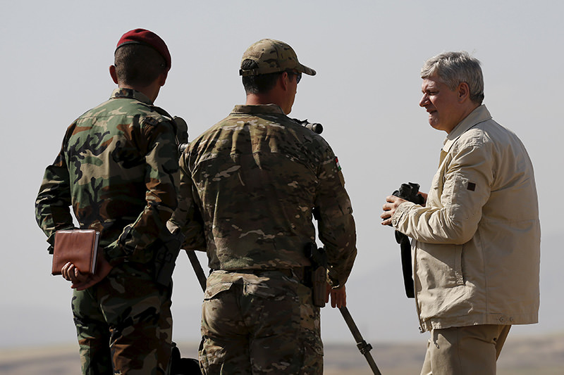 Canada's Prime Minister Stephen Harper (R) looks out towards Islamic State positions during his visit to Iraq in early May (Reuters Photo)