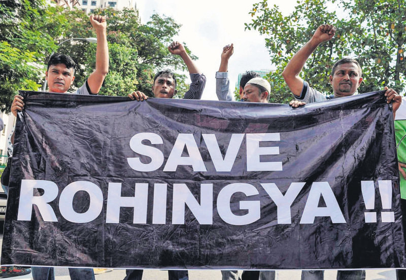 Ethnic Rohingya refugees from Myanmar residing in Malaysia hold a banner during a protest outside the Myanmar embassy in Kuala Lumpur on May 21, 2015.