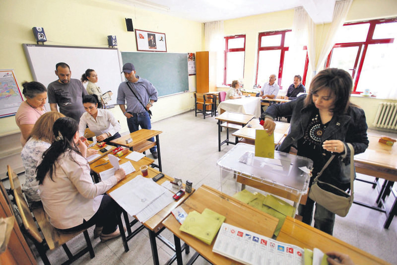 A woman casts her vote as others wait in line at a polling station in Ankara for the 2011 general elections.