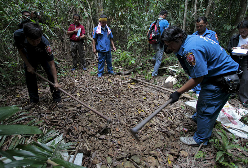 Security forces and rescue workers inspect a mass grave at a rubber plantation near a mountain in Thailand's southern Songkhla province May 7, 2015 (Reuters Photo)