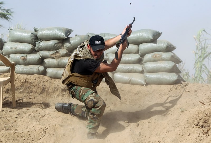 Iraqi Sunni fighters battling Islamic State (IS) alongside government forces fire their weapons on the outskirts of Iraq's Baiji oil refinery (AFP Photo)
