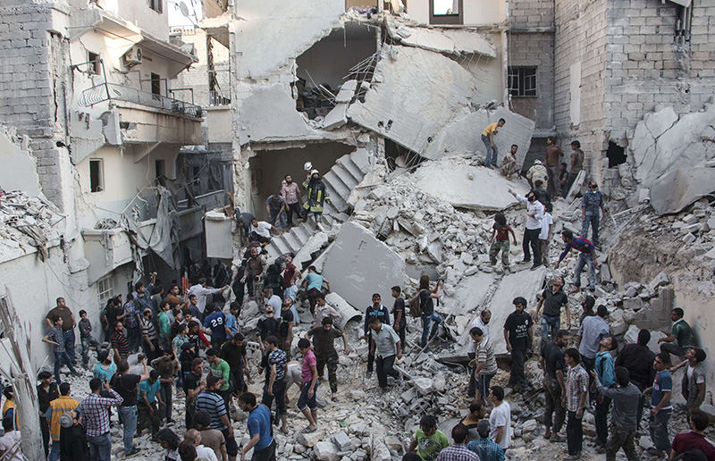 People gather at the scene after Syrian government forces allegedly dropped barrel bombs on the northern Syrian city of Aleppo, on May 30, 2015 (AFP Photo)