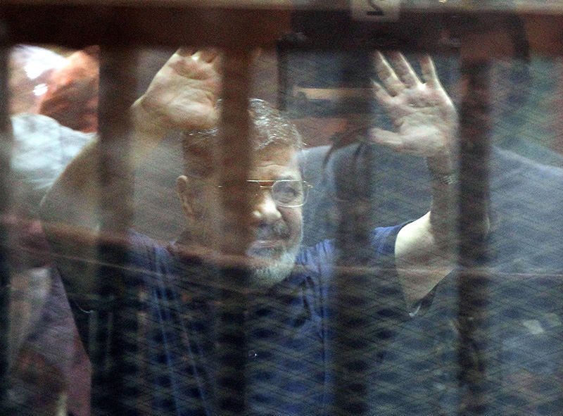A file photo dated 16 May 2015 showing Mohamed Morsi, gesturing from inside a cage in the courtroom where he stood trial in Cairo, Egypt (EPA Photo)