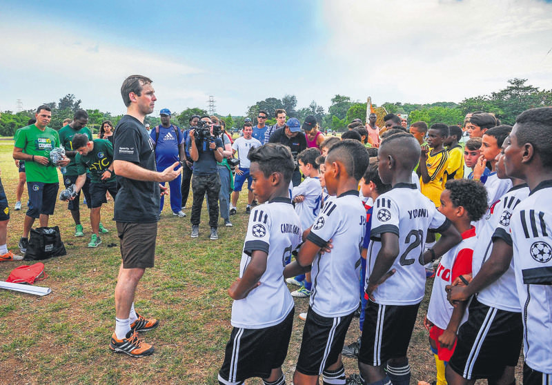 A New York Cosmos player speaks to children from Cuban football teams in Havana.