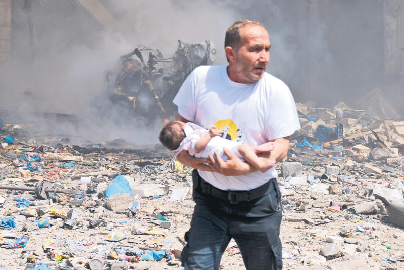 A man holds a baby that survived what activists said was a site hit by a barrel bomb dropped by the Assad regime in the old city of Aleppo on Wednesday.