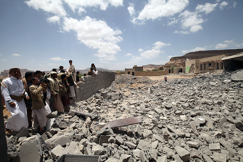 People look on, near the site of a building destroyed by a Saudi-led air strike near Sanaa, May 30, 2015 (Reuters Photo)