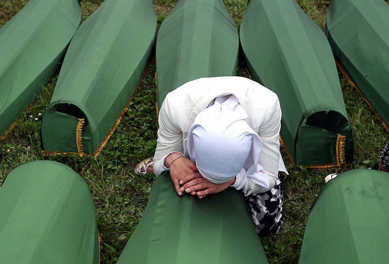 A Bosnian Muslim woman weeping over a casket at the Potocari Memorial Center during the funeral in Srebrenica, Bosnia and Herzegovina, where 175 newly-identified Bosnian Muslims were buried (EPA Photo)