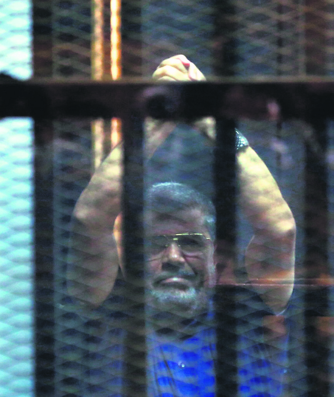 Ousted Egyptian President Morsi poses behind bars.