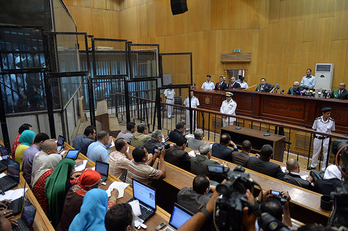 Egyptian defendants sit behind bars as journalists attend their retrial over a 2012 stadium riot in the canal city of Port Said that left 74 people dead on May 30, 2015 at the police academy in Cairo. (AFP Photo)