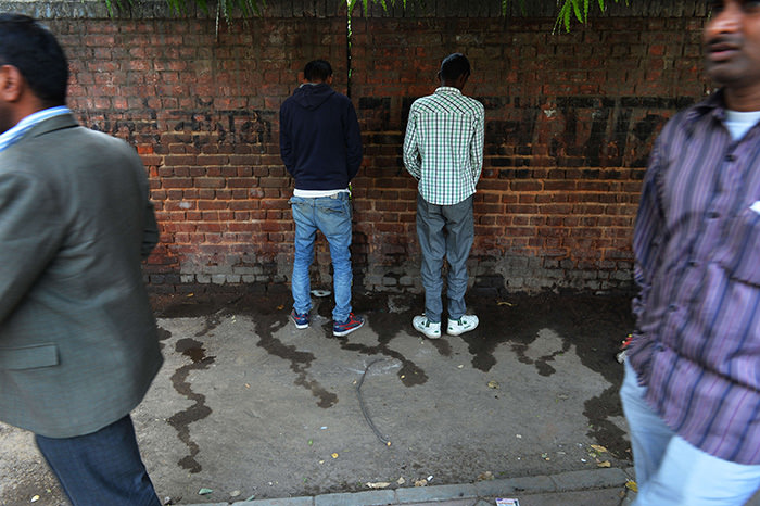Indian men urinate on a wall at the roadside in New Delhi, the eve of World Toilet Day (AFP Photo)