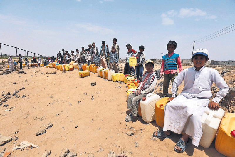 Yemeni children wait to fill jerry cans with water from a source donated by a benefactor amid ongoing disruption to water supplies in Sana'a on June 6.