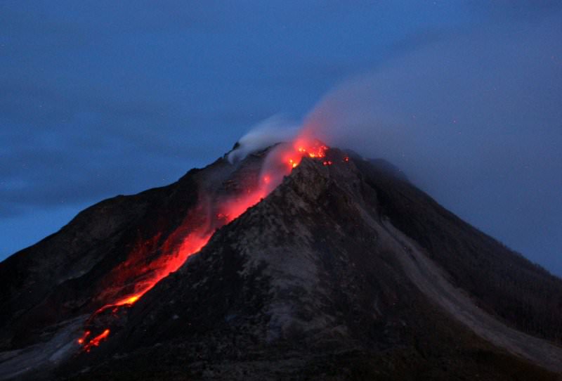 A long exposure picture shows molten lava spilling out from the crater of Mount Sinabung as it is seen from Tiga Serangkai village in Karo, North Sumatra, Indonesia, 13 June 2015 (EPA Photo)
