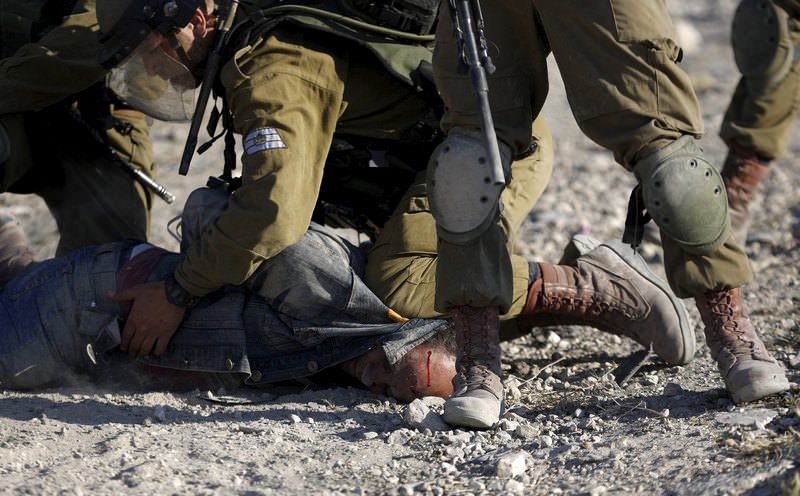 Israeli soldiers detain a Palestinian protester during clashes following a protest against Jewish settlements, in Jalazoun refugee camp, near the West Bank city of Ramallah June 12, 2015 (Reuters Photo)