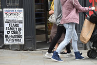 Pedestrians walk past a newsagents displaying a local paper headline on a notice board referring to fears regarding a missing family of 12 in Bradford, northern England, on June 16, 2015 (AFP Photo)