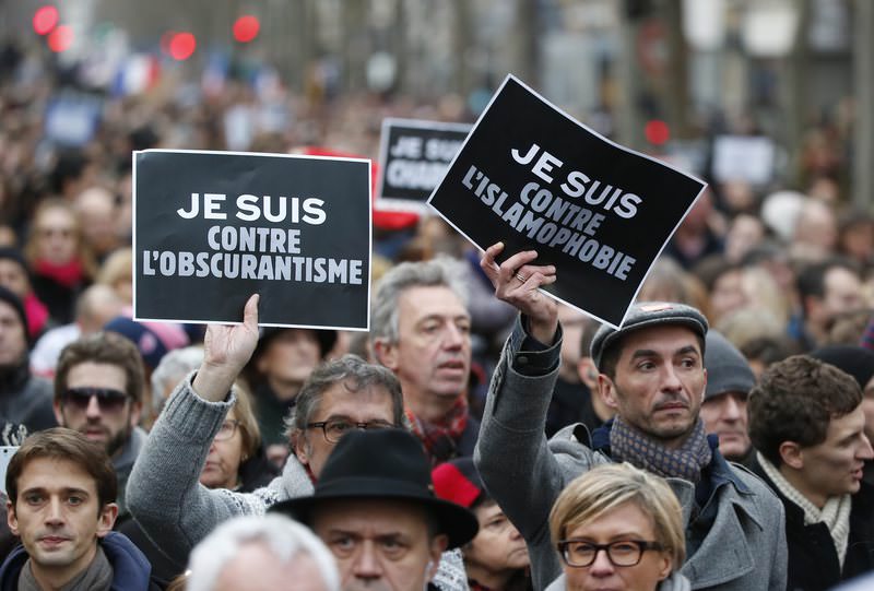 Demonstrators hold posters reading ,I am against obscurantisme,, left, and ,I am against Islamophobia, during a march in Paris, France, Sunday, Jan. 11, 2015 (AP Photo)