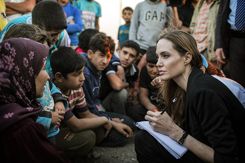 Angelina Jolie taking notes as she speaks with Syrian refugees in a Jordanian military camp based near the Syria-Jordan border on June 18, 2013 (AP Photo)