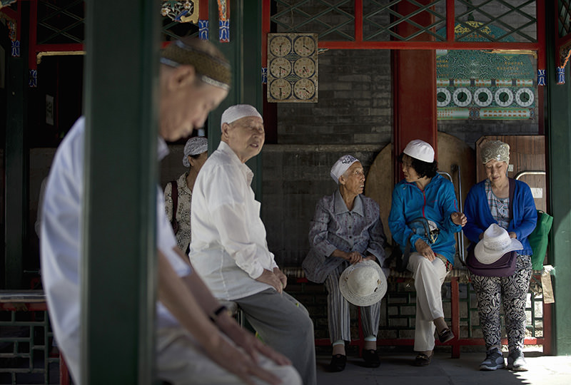 Chinese Muslim chat outside the worship hall on the first day of the Muslim holy month of Ramadan at the Niujie Mosque, the oldest and largest mosque in Beijing, China Thursday, June 18, 2015 (AP Photo)