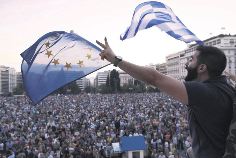 Demonstrators wave European and Greek flags as they stand in front of parliament in Athens on June 18.