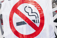 A large anti-smoking banner hangs on the exterior of the Bird's Nest stadium as a tourist walks by in Beijing, China. Beijing implemented a new smoking ban that took affect June 1.