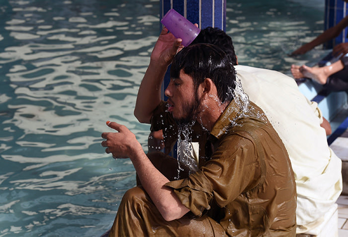 A Pakistani man cools down with water at a mosque during a heatwave in Karachi on June 22, 2015 (AFP Photo)