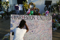  Jennice Barr, 10, leaves a message on a board set up in front of the Emanuel African Methodist Episcopal Church after a mass shooting at the church killed nine people, on June 22, 2015 (AFP Photo)