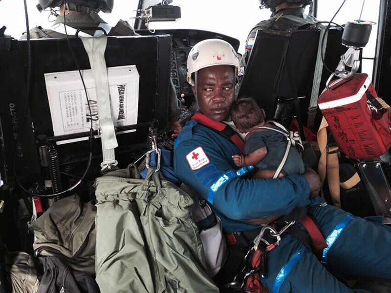 Handout photo released on June 24, 2015 of a Red Cross member holding baby Yudier Moreno as he and his mother are transported on a helicopter to a hospital in Colombia (AFP Photo)