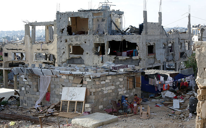 Palestinian children play next the remains of their house on June 22, 2015 in Gaza City that was destroyed during 50-day war between Israel and Hamas-militants in the summer of 2014. (AFP Photo)