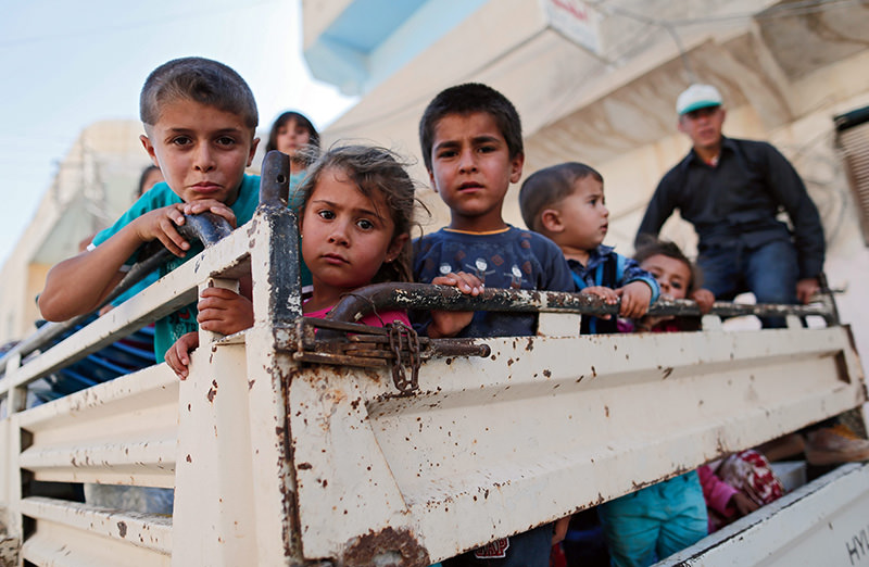 Syrian children are carried by a truck in east of Kobane in Syria, 22 June 2015 (EPA Photo)