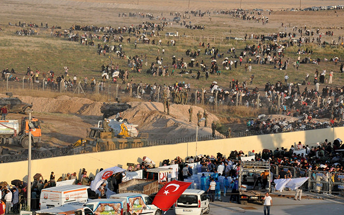 Syrian refugees from Tel Abyad (foreground) line up at the border crossing as the others wait behind the fences to cross into Turkey at the Akcakale border gate in Sanliurfa province, Turkey, June 14, 2015 (Reuters Photo)