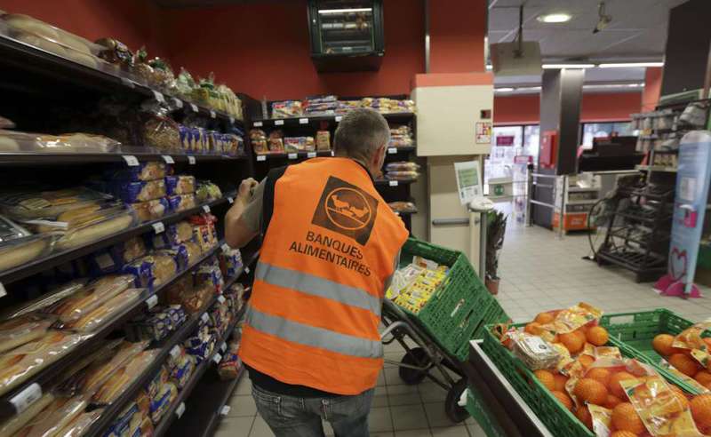 Guy, a retired train engineer, who volunteers at the ,Banques Alimentaires, (Food Bank), pushes a trolley with food goods donated by a supermarket to charity organisations in l'Hay-les-Roses, France.