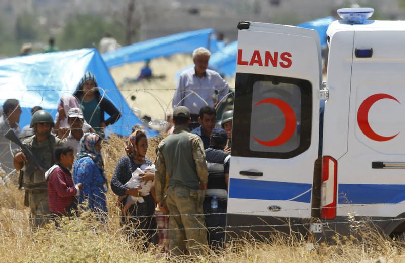 Syrian Kurds from Kobani who need medical help are taken to an ambulance on the Turkish-Syrian border in the Suruu00e7 district of u015eanlu0131urfa province.