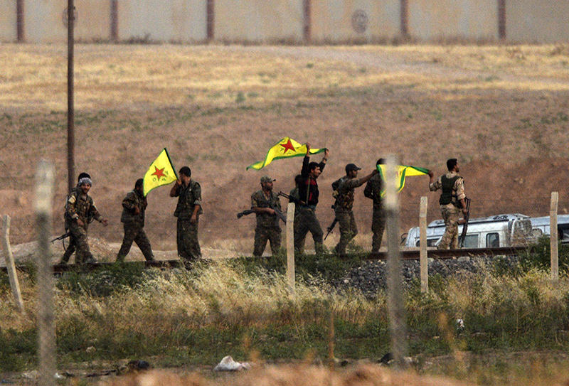 Kurdish  YPG fighters hold their movement's flag near the Aku00e7akale crossing gate between Turkey and Syria at Aku00e7akale in u015eanlu0131urfa province (AFP Photo)