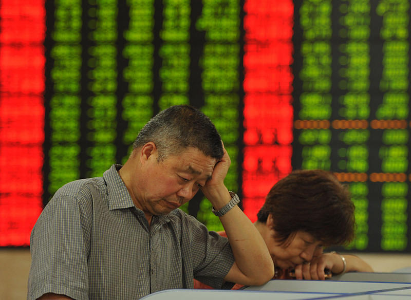 This photo taken on June 26, 2015 shows investors checking the share prices in a stock firm in Fuyang, east China's Anhui province (AFP Photo)