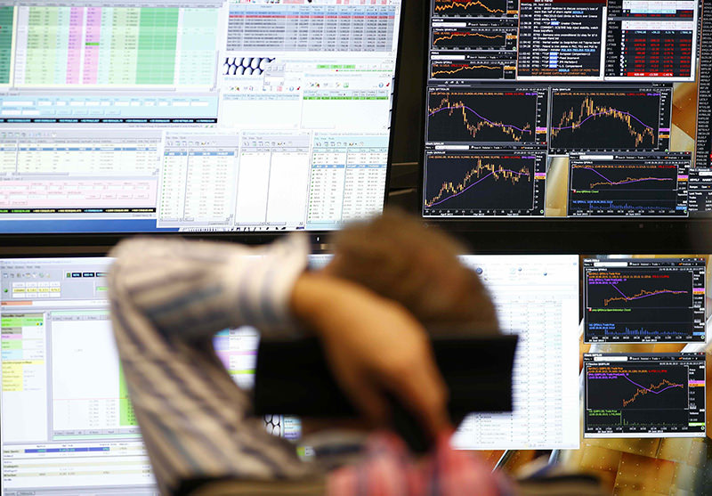 A trader sits in front of the computer screens at his desk at the Frankfurt stock exchange, Germany (Reuters Photo)