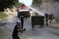 Palestinian protester hurl stones at Israeli Army water canon during clashes which following a protest against Israeli settlements in Qadomem, Kofr Qadom village, near the West Bank city of Nablus, 05 June 2015 (EPA Photo)