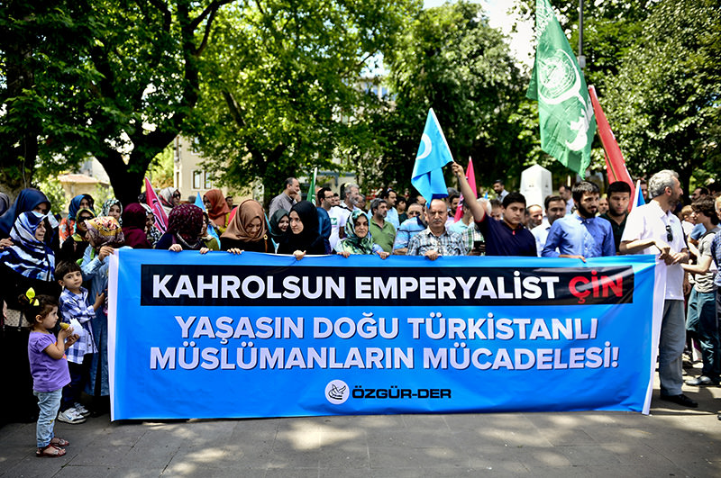 Protesters carrying banner which says: Down with Imperialist China, Long live the struggle of East Turkistan Muslims (AA Photo) 