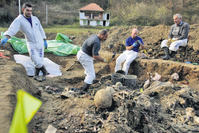 Forensic experts of the International Commission for Missing Persons (ICMP) search for human remains in a mass grave in the village of Kamenica