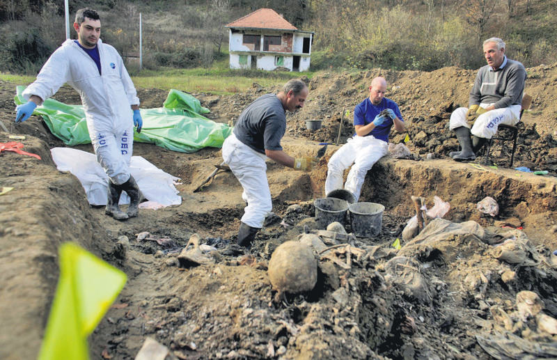 Forensic experts of the International Commission for Missing Persons (ICMP) search for human remains in a mass grave in the village of Kamenica