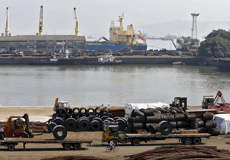 A worker rides his bicycle past steel rims in a dockyard at Mumbai Port Trust in Mumbai in this November 17, 2014 file photo (REUTERS photo)