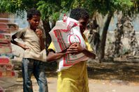 A Yemeni boy receives food aid from a local relief group providing aid to thousands affected by the ongoing fighting in the central city of Taiz, Yemen